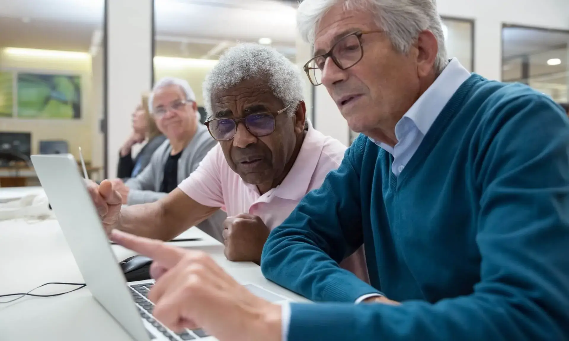 Persones grans col·laborant i aprenent tecnologia